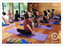 Several people taking part in an afternoon yoga class being taught in the Amazon Yoga Center's large, light-filled studio in on the outskirts of the Tambopata Rainforest Reserve