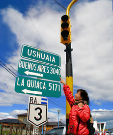 A visitor consults road signs to get her bearings in Ushuaia, the southernmost city in the world, located on the southern shore of Isla Grande de Tierra del Fuego