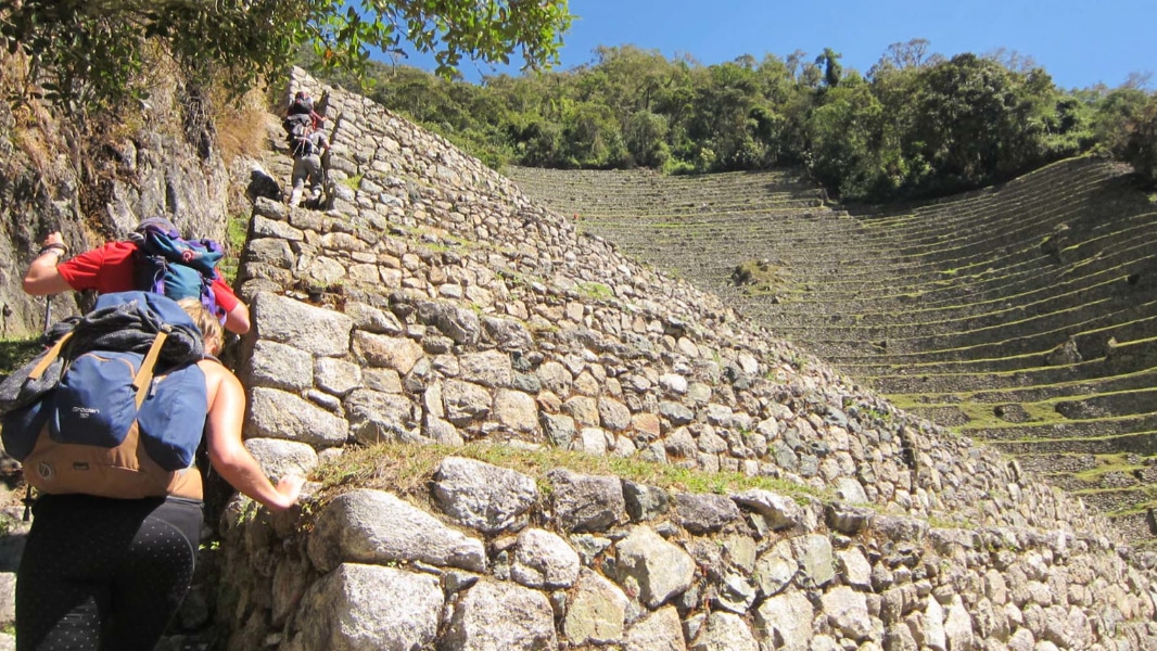 Inca trail hikers ascend the stone stairs at Wiñaywayna