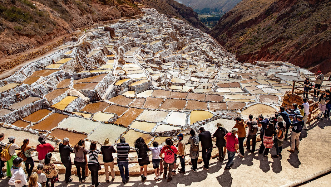 Visitors on the viewing platform overlooking the Salineras salt pans at Maras in Cusco, Peru