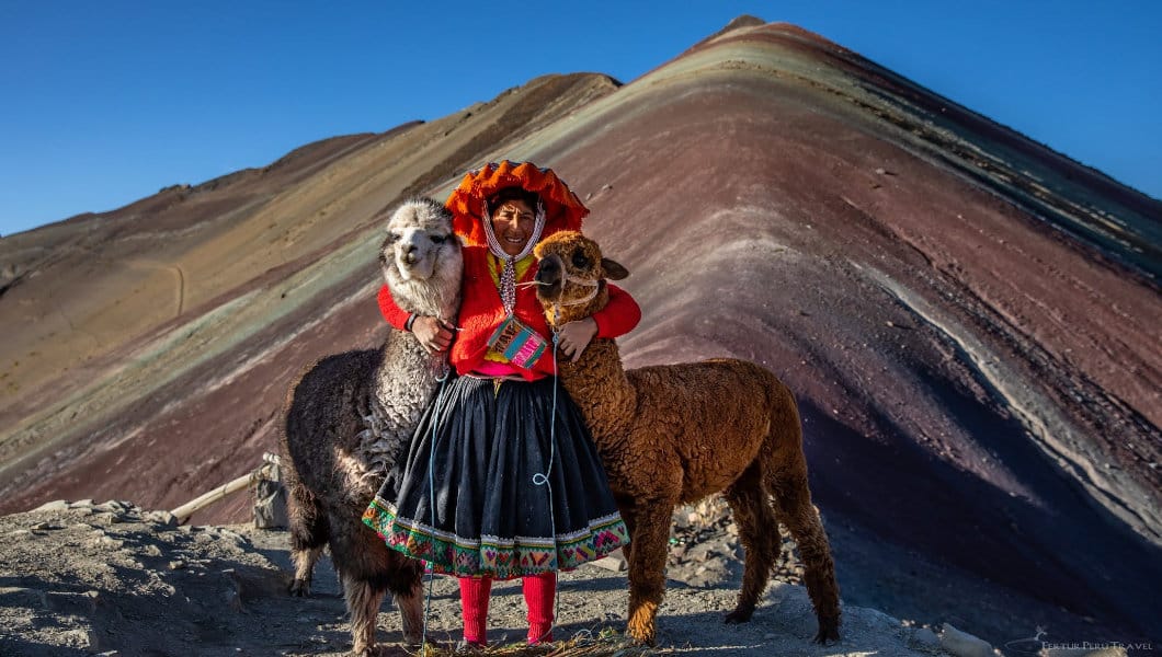 Local woman with her llamas at the summit of Rainbow Mountain (Vinicunca) in Cusco