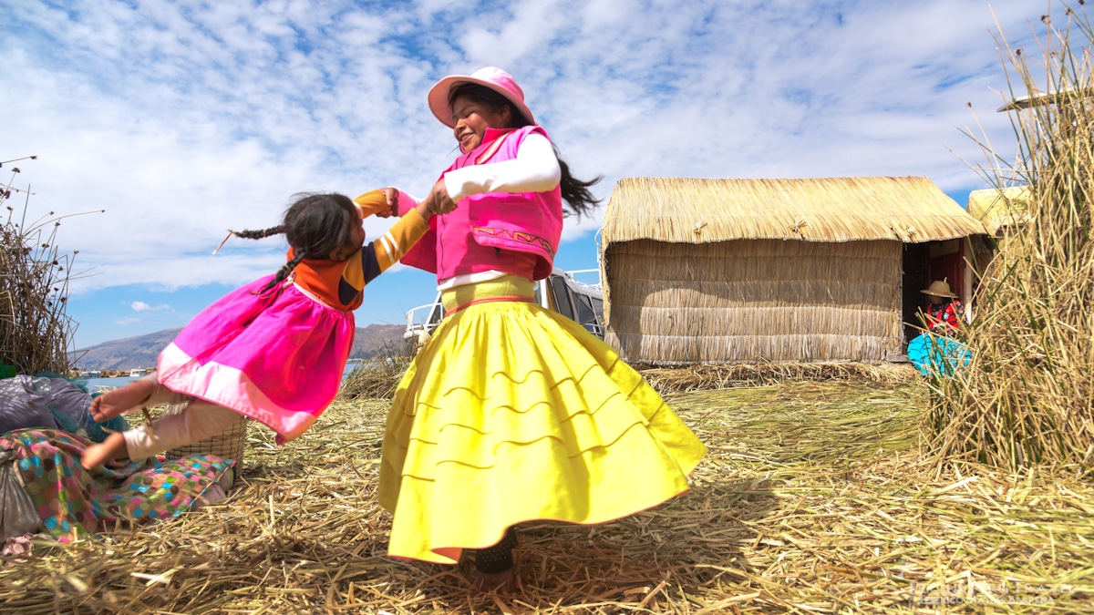 A local mother plays with her little girl on the floating Islands of Uros on Lake Titicaca